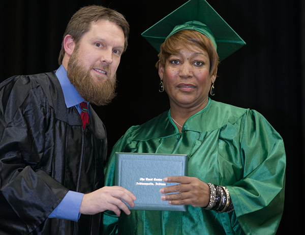 Brenda's coach at The Excel Center was proud to hand her her diploma