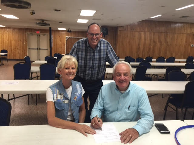 Goodwill CEO Kent Kramer and Candy Barksdale sign the merger agreement